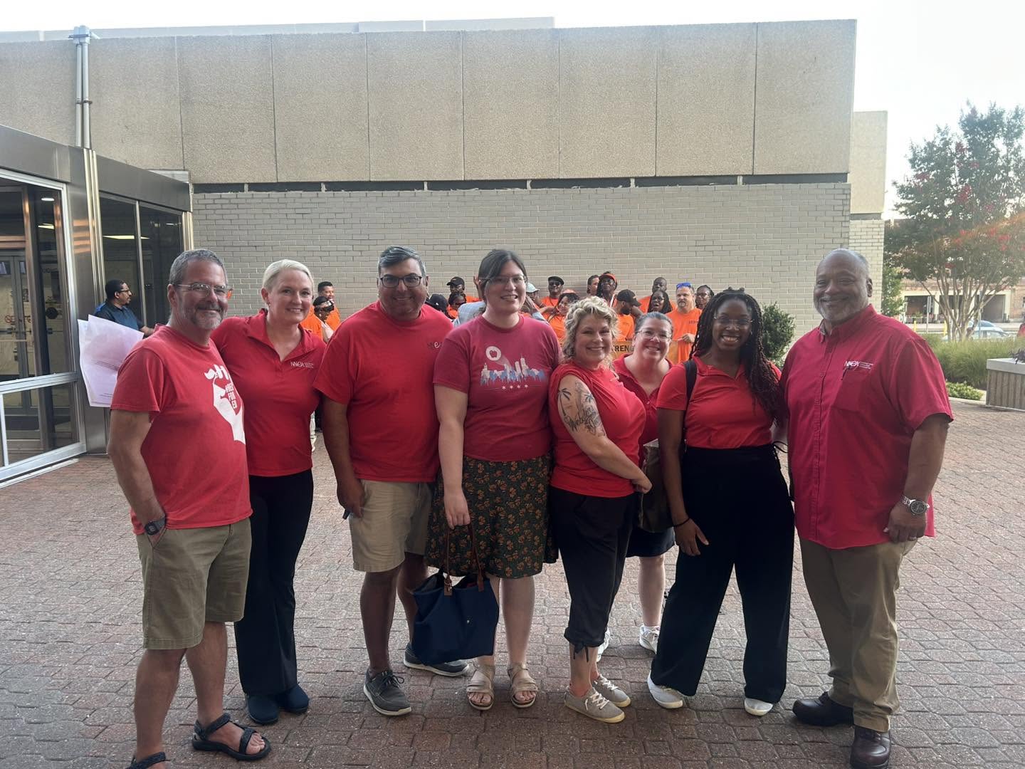 NNEA members wearing red outside of City Council on July 14th.